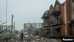 Một người dân địa phương đi ngang qua một tòa nhà bị hư hại do pháo kích khi Nga tiếp tục tấn công Ukraine, tại thành phố Makariv, vùng thủ đô Kyiv, Ukraine, ngày 1 tháng 4 năm 2022.