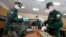 FILE - A Russian officer, left, hands face masks to a conscript at a military conscription office in Moscow, May 22, 2020. 