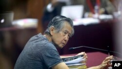 El expresidente peruano Alberto Fujimori, fotografiado a través de una ventana de vidrio, asiste a su juicio en una base policial en las afueras de Lima, Perú, el 23 de abril de 2014.