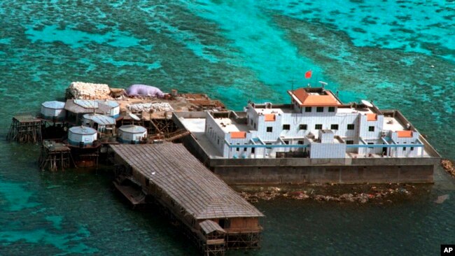 FILE - A Chinese flag flies from one of the two newly-finished concrete structures on the Mischief Reef off the disputed Spratlys group of islands in the South China Sea in this aerial photo taken on Monday, Feb. 8, 1999. (AP Photo/Aaron Favila)