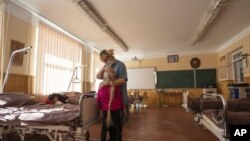Nadja grli desetogodišnju unuku Zlatu, koja pati od hroničnih srčanih problema, u poljskoj bolnici u jednoj školi u mestu Mostiska, u zapadnoj Ukrajini (Foto: AP/Nariman El-Mofty)