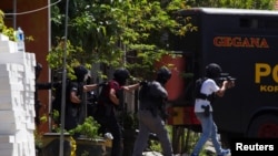 Pasukan polisi antiteror bergerak dalam operasi penyerbuan sebuah rumah yang diduga terdapat teroris di dalamnya di wilayah Medokan Ayu, Surabaya, Jawa Timur, pada 15 Mei 2018. (Foto: Reuters/Sigit Pamungkas)