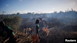 Felix Fitiavantsoa, 20, and his brother start a fire in a wooded area in order to start cultivating it, in the Tsihombe commune, Androy region, Madagascar, February 13, 2022. (REUTERS/Alkis Konstantinidis )