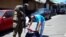 Un miembro del ejército revisa los documentos y pertenencias de un hombre en plena calle durante un patrullaje después de que el Congreso de El Salvador aprobara el domingo poderes de emergencia que suspendieron temporalmente algunas protecciones constitucionales.