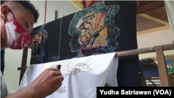 Pekerja penyandang difabel sedang membatik motif motogp Mandalika di Batik Toeli Laweyan Solo. (Foto: VOA/Yudha Satriawan)