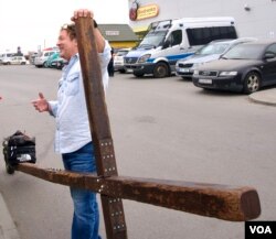 El autoproclamado peregrino portador de la cruz, Keith Wheeler, dice: "La gente necesita alimentos, agua, medicamentos. Pero más que nada, la gente necesita esperanza. Y no se le puede poner precio a la esperanza". [Jamie Dettmer/VOA]