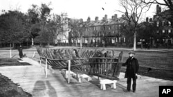 This 1865 photo provided by the Pilgrim Hall Museum, shows Leander Cosby, of Orleans, Massachussetts., right, standing with remains of the 1626 shipwreck Sparrow-hawk, on the Boston Common, in Boston. 