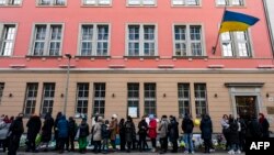 People queue in front of the Ukrainian embassy to receive a dose of COVID-19 vaccine, in Berlin, Germany, March 10, 2022.