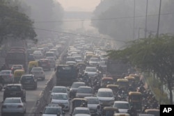 Para komuter berkendara di tengah kabut pagi dan kabut asap beracun di New Delhi, India, Rabu, 17 November 2021. (AP/Manish Swarup)