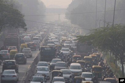 Para komuter berkendara di tengah kabut pagi dan kabut asap beracun di New Delhi, India, Rabu, 17 November 2021. (AP/Manish Swarup)