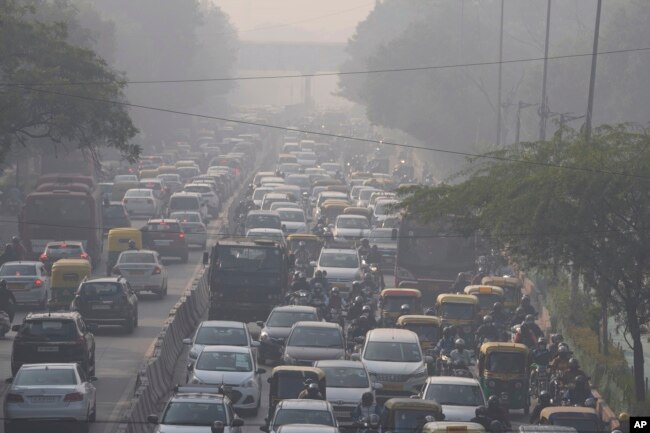 Para komuter berkendara di tengah kabut pagi dan kabut asap beracun di New Delhi, India, Rabu, 17 November 2021. (AP/Manish Swarup)