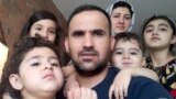 This August 17, 2021, image courtesy of Mohammad Ehsan Saadat shows Ehsan Saadat, a 33-year-old Afghan, who recently arrived in Canada, posing with his wife and his children in Toronto.
