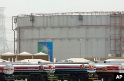 Truk bahan bakar mengantre di depan tangki penyimpanan di pabrik curah Jeddah Utara, fasilitas minyak Aramco, di Jeddah, Arab Saudi, pada 21 Maret 2021. (Foto: AP)