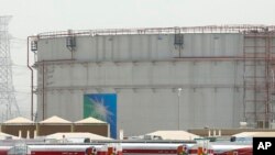 FILE - Fuel trucks line up in front of storage tanks at the North Jiddah bulk plant, an Aramco oil facility, in Jiddah, Saudi Arabia, on March 21, 2021.