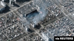 A satellite image shows burning and destroyed apartment buildings, in Mariupol, Ukraine, March 22, 2022.