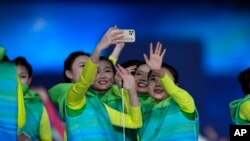 Participants pose for a selfie after the closing ceremony at the 2022 Winter Paralympics, in Beijing, March 13, 2022.