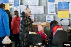 Una madre refugiada ucraniana toma un poco de sopa en la estación central de Varsovia. [Jamie Dettmer/VOA]