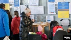 A Ukrainian refugee mother grabs some soup at Warsaw’s Central Station. (Jamie Dettmer/VOA)