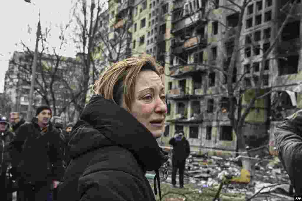 A woman reacts as she stands outside destroyed apartment blocks following shelling in the northwestern Obolon district of Kyiv, March 14, 2022.&nbsp;Two people were killed as various neighborhoods of the Ukraine capital Kyiv came under shelling and missile attacks, city officials said, after the Russia&#39;s military invaded the Ukraine on Feb. 24, 2022.