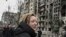 A woman reacts as she stands outside destroyed apartment blocks following shelling in the northwestern Obolon district of Kyiv, March 14, 2022.&nbsp;Two people were killed as various neighborhoods of the Ukraine capital Kyiv came under shelling and missile attacks, city officials said, after the Russia's military invaded the Ukraine on Feb. 24, 2022.