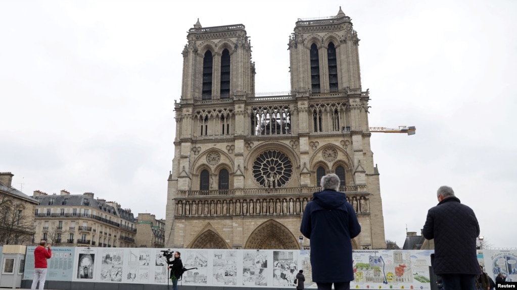 People look at the Notre-Dame de Paris Cathedral as its Emmanuel tenor bell rings to "call for peace in Europe", following Russia's invasion of Ukraine, in Paris, France, March 3, 2022. (REUTERS/Johanna Geron) 