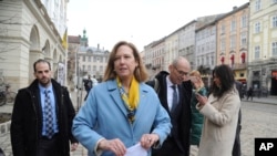 La embajadora interina de Estados Unidos ante Ucrania, Kristina Kvien, en el centro, camina en Leópolis, Ucrania, el martes 15 de febrero de 2022.