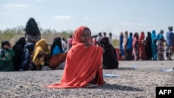 Une fille est assise alors qu'elle fait la queue avec des dizaines d'autres personnes déplacées à l'intérieur du pays pour être enregistrées par les autorités locales dans un complexe à Semera, dans la région d'Afar, en Éthiopie, le 14 février 2022.