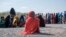 FILE - A girl sits as she waits in line with dozens of other internally displaced people to be registered by local authorities at a compound in Semera, Afar region, Ethiopia, Feb. 14, 2022. 