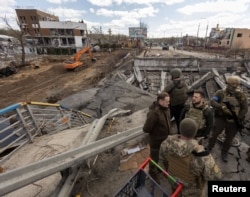 Ukraine's President Volodymyr Zelenskiy stands on a destroyed bridge in the town of Irpin, as Russia's attack on Ukraine continues, outside of Kyiv, Apr. 4, 2022. (Ukrainian Presidential Press Service/Handout via Reuters)