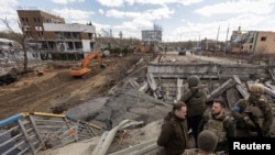 Ukraine's President Volodymyr Zelenskyy stands on a destroyed bridge in the town of Irpin, as Russia's attack on Ukraine continues, outside of Kyiv, April 4, 2022. (Ukrainian Presidential Press Service/Handout via Reuters)