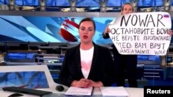 Potongan gambar dari video siaran berita yang menampilkan seorang demonstran antiperang menginterupsi siaran langsung sebuah stasiun televisi berita Rusia. (Foto: Channel One via Reuters)