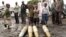 Congolese citizens look at tank shells lying next to roadside, left behind by retreating government troops as they fled assault by M23 rebels, in eastern Congo, Nov. 21, 2012.