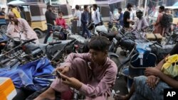 FILE - A youngster uses the social media app TikTok on his phone, at a market in Karachi, Pakistan, July 21, 2020. 