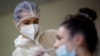 FILE - A medical worker administers a nasal swab to a patient at a COVID-19 testing center in Les Sorinieres, France, June 23, 2022. 