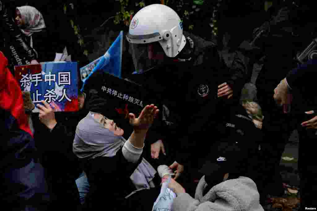 Ethnic Uyghur demonstrators scuffle with riot police during sit-in protest of China, in front of the Chinese consulate in Istanbul, Turkey.