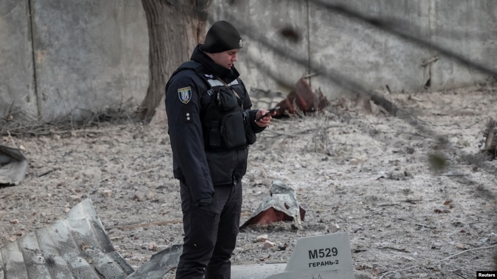 A police officer stands near parts of the drone at the site of a building destroyed by a Russian drone attack, as their attack on Ukraine continues, in Kyiv, Ukraine December 14, 2022. The inscription reads 'For Ryazan'. (REUTERS/Gleb Garanich)