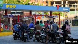 Conductores de motocicletas esperan para obtener gasolina en medio de repetidos apagones en las refinerías operadas por la petrolera estatal PDVSA y la falta de importaciones de diésel y gasolina, en Maracay, Venezuela, el 9 de diciembre de 2022.