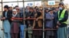 Afghan men stand in queues to receive food aid from a non-governmental organisation (NGO) in Kabul, Dec. 25, 2022. 