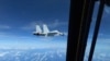 In this image taken from a Dec. 21, 2022, video, a Chinese Navy J-11 fighter jet flies close to a U.S. Air Force RC-135 aircraft in international airspace over the South China Sea, according to the U.S. military. (Image from U.S. Indo-Pacific Command/Handout via Reuters)