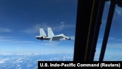 A Chinese Navy J-11 fighter jet flies close to a U.S. Air Force RC-135 aircraft in international airspace over the South China Sea, according to the U.S. military, in a video still taken Dec. 21, 2022. 