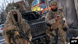 FILE - Taliban security personnel stand guard along a road in Kabul, Afghanistan, Dec. 21, 2022. 