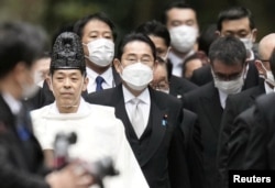 Perdana Menteri Jepang Fumio Kishida dan para menteri kabinetnya dipimpin oleh seorang pendeta shinto dalam kunjungan adat Tahun Baru di kuil Ise di Ise, Jepang tengah, 4 Januari 2023. (Kredit wajib Kyodo via REUTERS)
