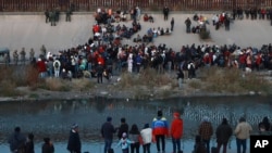 FILE - Migrants gather at a crossing into El Paso, Texas, as seen from Ciudad Juarez, Mexico, Dec. 20, 2022. (AP Photo/Christian Chavez, File)