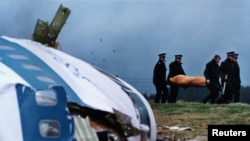 Lockerbie မြို့အနီးလေယာဉ်ပျက်ကျမှုကြောင့်သေဆုံးခဲ့သူတဦးရဲ့ရုပ်အလောင်းသယ်ဆောင်နေပုံ၊ ဒီဇင်ဘာ ၂၂၊ ၁၉၈၈။ 
