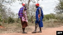 FILE - Maasai men converse at the Msomera village in Handeni, Tanzania, July 15, 2022. Tanzanian authorities have started rationing electricity because of a drop in hydropower generation brought on by drought, the national provider said Nov. 23, 2022.