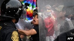 Supporters of former President Pedro Castillo clash with riot police during a demonstration demanding his release and the closure of the Peruvian Congress in Lima, on Dec. 11, 2022.