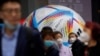 戴著口罩的上海民眾走過2022卡塔爾世界杯比賽用球模型。 （2022年11月23日）