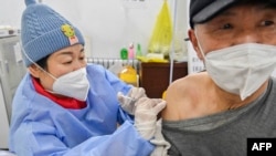 Seorang pria menerima suntikan vaksin COVID-19 di Qingzhou, China, pada 29 Desember 2022. (Foto: AFP)