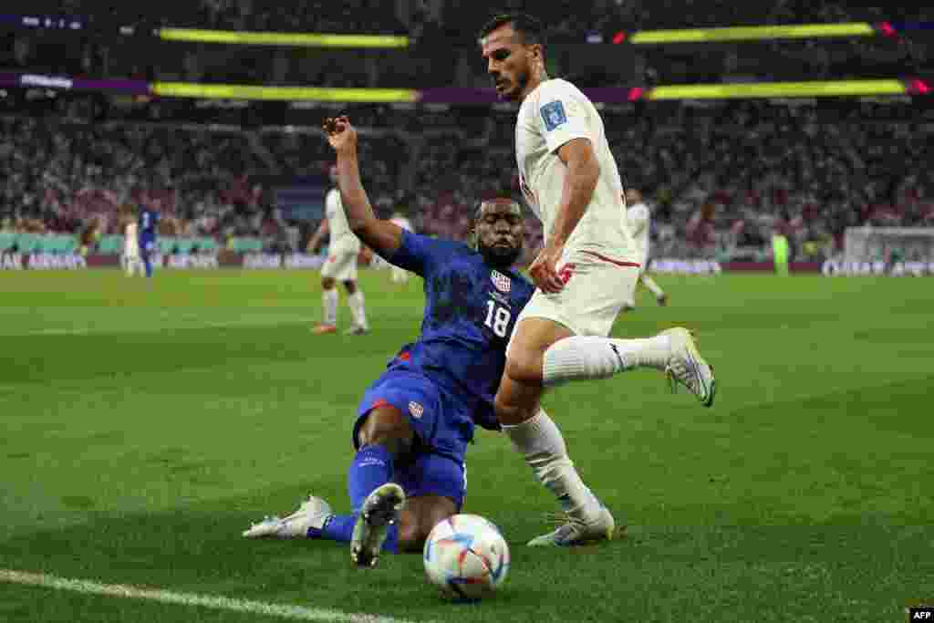 Défenseur ya Etast-Unis #19 Shaq Moore (L) azali kowela ndembo na défenseur ya Iran #25 Abolfazi Jalali na match ya groupe B ya Mondial Qatar 2022 na stade Al-Thumama, Doha, 29 novembre 2022. (Photo FADEL SENNA / AFP)
