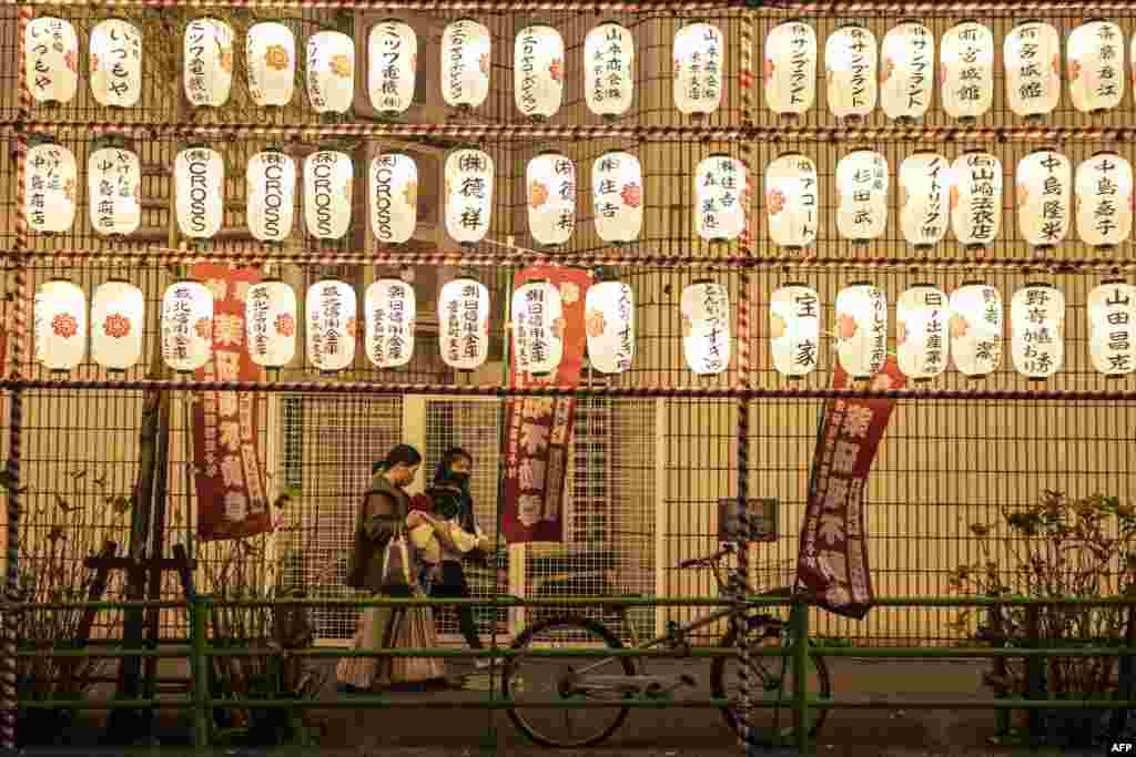 Луѓето поминуваат покрај хартиените фенери на саемот за крајот на годината во областа Нихонбаши во Токио, Јапонија.